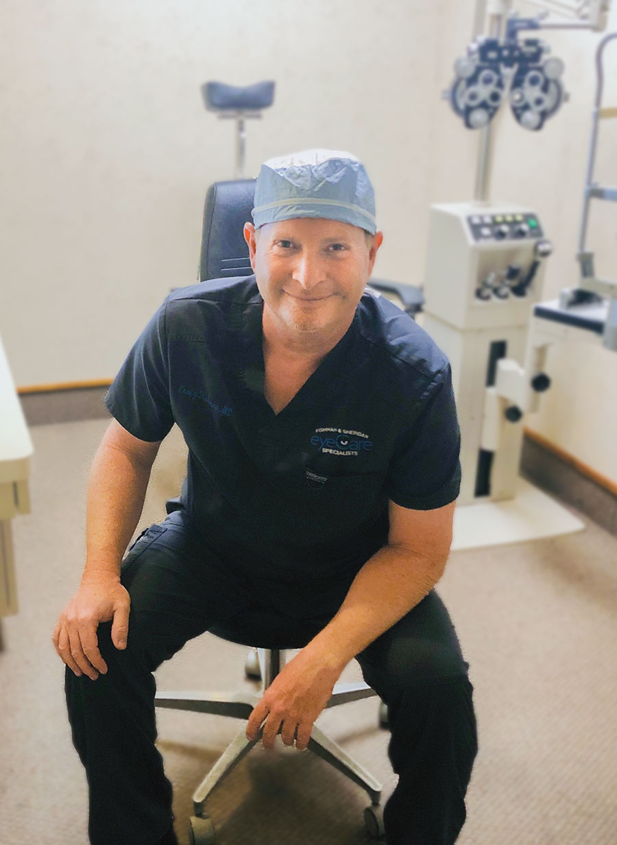 Dr. Craig Fishman in medical scrubs sitting on a chair 